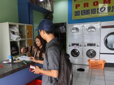 Pekerja melayani pelanggan di toko laundry di Jakarta, Rabu (20/6). Libur lebaran banyak jasa laundry kebanjiran order hingga 100 karena banyaknya para pembatu rumah tangga yang mudik lebaran. (Liputan6.com/Angga Yuniar)