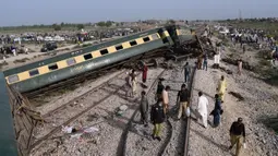 Sepuluh gerbong kereta Hazara Express dilaporkan tergelincir dan terbalik di dekat stasiun kereta Sahara di Nawabshah, sekitar 275 km dari Kota Karachi. Kereta tersebut tengah dalam perjalanan dari Karachi ke Havelian. (AP Photo/Umair Ali)
