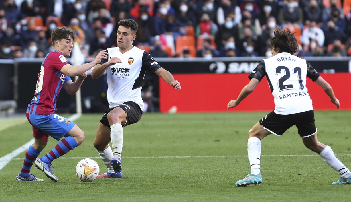 Pada menit ke-74 dan 79, Valencia memiliki peluang memangkas ketertinggalan. Dua peluang yang diperoleh Hugo Duro (tengah) lewat sundulan dan sepakan kakinya nyatanya masih mampu dimentahkan kiper Barcelona, Marc-Andre ter Stegen. (AP/Alberto Saiz)