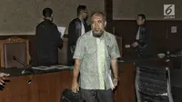 Patrialis Akbar bersiap meninggalkan ruangan usai menjalani sidang perdana di Tipikor, Jakarta, Selasa (13/6). Suap tersebut diterima dari pengusaha impor daging sapi, Basuki Hariman melalui perantara Ng Fenny dan Kamaludin. (Liputan6.com/Helmi Afandi)