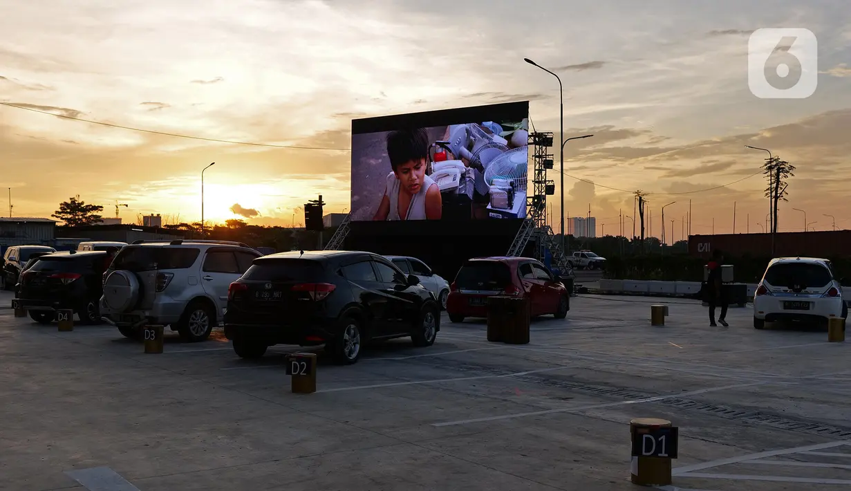 Deretan mobil penonton terparkir saat menyaksikan pemutaran film secara drive-in di Cikarang, Bekasi, Jawa Barat, Rabu (3/6/2020). Kehadiran drive-in cinema memberikan hiburan alternatif kepada warga di tengah pandemi virus corona COVID-19. (Liputan6.com/Herman Zakharia)