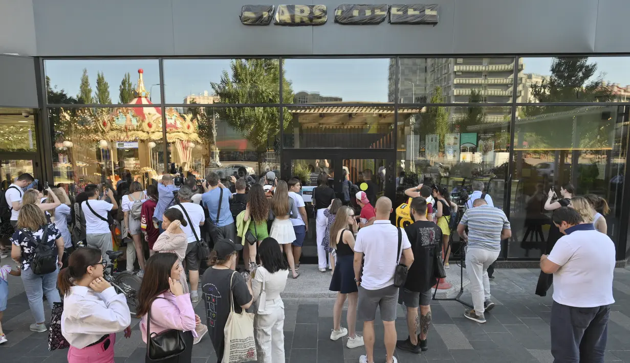 Orang-orang berkumpul untuk mengunjungi kedai kopi Stars Coffee yang baru dibuka di bekas lokasi gerai kopi Starbucks di Moskow, Rusia, Kamis (18/8/2022). Jaringan kedai kopi baru dibuka pada Kamis di Moskow, setelah penyanyi dan pengusaha Rusia Timur Yunusov, lebih dikenal sebagai Timati, bersama dengan pemilik restoran Rusia Anton Pinskiy membeli toko Starbucks setelah hengkangnya perusahaan asing dari negara itu. (AP Photo/Dmitry Serebryakov)