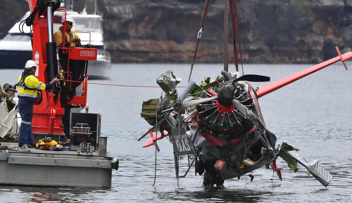 Kepolisian New South Wales dan petugas penyelamat mengangkat bangkai pesawat amfibi yang jatuh di Sungai Hawkesbury, utara Sydney, Kamis (4/1). Bangkai kapal diangkat dari dasar sungai ke sebuah tongkang. (Mick Tsikas/AAP Images via AP)