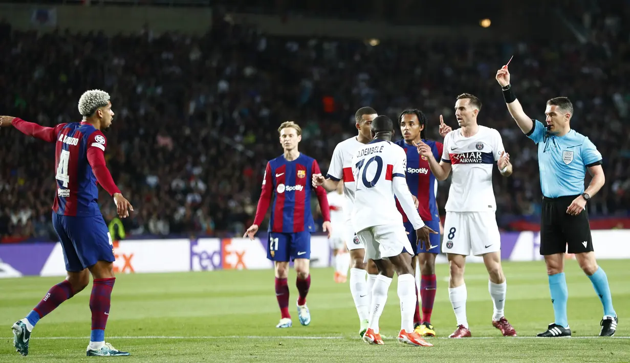 Wasit Istvan Kovacs memberikan kartu merah kepada pemain Barcelona, Ronald Araujo, saat melawan Paris Saint-Germain pada duel leg kedua perempat final Liga Champions 2023/2024 Stadion Olimpic Lluis Companys, Rabu (17/4/2024). (AP Photo/Joan Monfort)