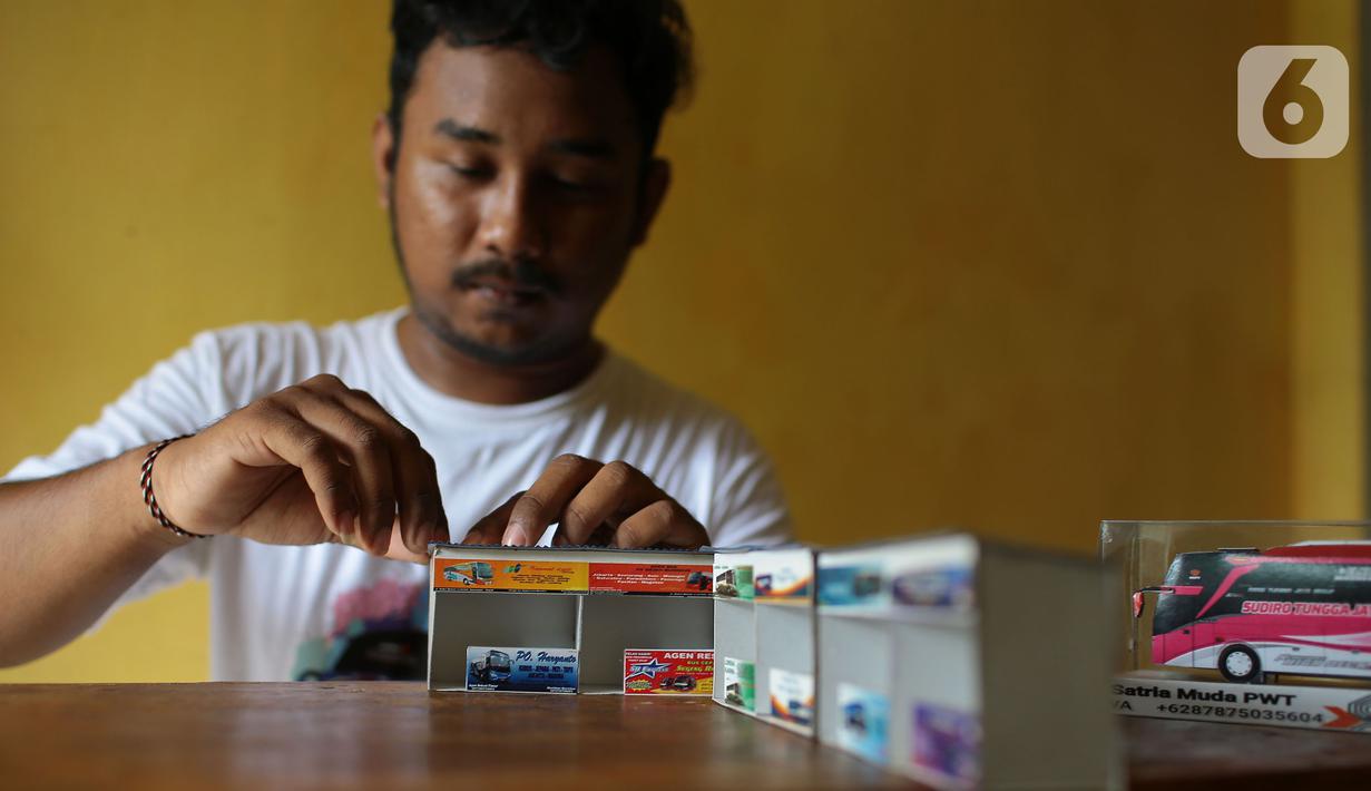 Perajin menyelesaikan pembuatan miniatur loket bus yang terbuat dari karton daur ulang di kawasan Parung Bingung, depok, jawa Barat, Minggu (3/7/20222). Dalam sehari ia mampu memproduksi 10 item miniatur dengan harga antara Rp 15 ribu hingga Rp 300 ribu. (merdeka.com/Arie Basuki)