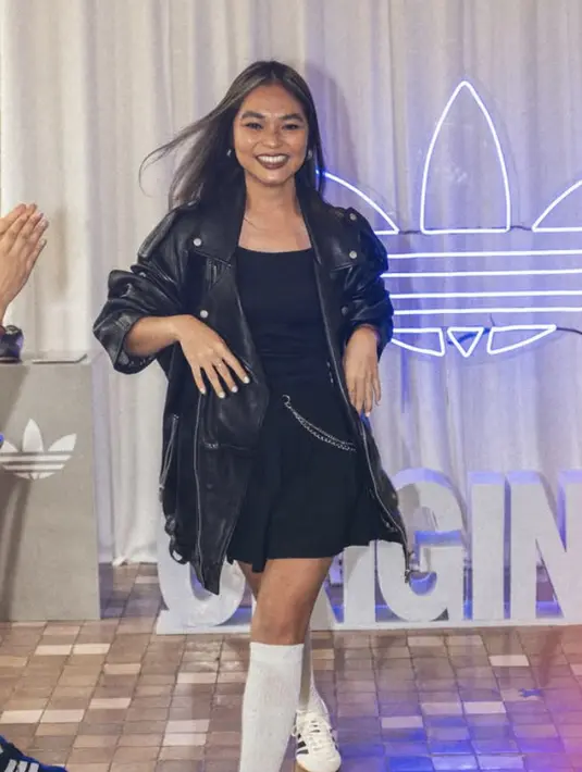 Regina Poetiray juga tampil begitu chic bergaya glam rock dengan jaket kulit, mini skrit disertai aksen rantai serta paduan kaos kaki high knee dengan Adidas Taekwondo. [Foto: Instagram/ Andrea Bimo]