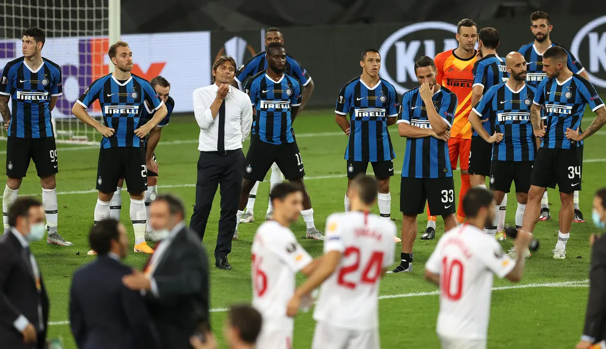 Pemain Inter Milan tampak lesu menyaksikan pemain Sevilla merayakan gelar juara Liga Europa 2019/2020 di Stadion RheinEenergie, Sabtu (22/8/2020) dini hari WIB. Inter Milan kalah 2-3 atas Sevilla. (AFP/Lars Baron/pool)