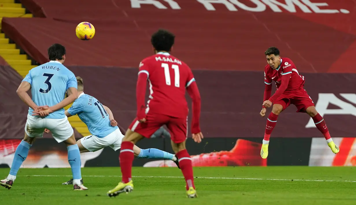 Gelandang Liverpool, Roberto Firmino (kanan) melepaskan tendangan ke arah gawang Manchester City dalam laga lanjutan Liga Inggris 2020/21 pekan ke-23 di Anfield Stadium, Minggu (7/2/2021). Liverpool kalah 1-4 dari Manchester City. (AFP/Tim Keeton/Pool)