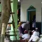 Para siswa SD Negeri Pelangwot mengerjakan soal ujian sambil duduk di lantai.