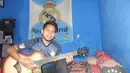 Andik Vermansah bersantai dalam kamarnya di rumah orang tuanya yang penuh dengan atribut Real Madrid dan Manchester United. (Bola.com/Zaidan Nazarul)