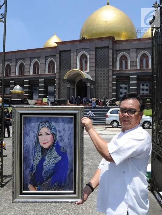 Kerabat menunjukkan foto Hj. Djuriah Rais atau dikenal dengan nama Dian Al Mahri sebelum pemakaman di area Masjid Kubah Emas, Cinere, Depok, Jumat (29/3). Pendiri Masjid Kubah Emas tersebut meninggal dunia pada Jumat dini hari tadi di usia 70 tahun. (merdeka.com/Arie Basuki)