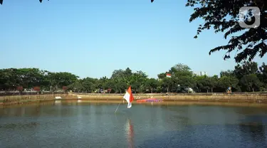 Bendera Merah Putih berdiri di tengah Waduk Cavalio, Jakarta, Jumat (4/10/2019). Dinas Sumber Daya Air DKI Jakarta mengalokasikan anggaran sebesar Rp 288,49 miliar pada 2020 untuk program naturalisasi sungai dan waduk guna mengatasi masalah banjir di Ibu Kota. (Liputan6.com/JohanTallo)