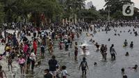 Pengunjung berenang di Pantai Karnaval Ancol, Jakarta, Jumat (14/5/2021). Pemprov DKI Jakarta pada libur Lebaran 2021 membuka sejumlah tempat wisata, salah satunya Ancol. (Liputan6.com/Johan Tallo)