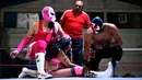 Pegulat wanita Meksiko, Brillo de Luna (bawah) tampil di 2 de Junio Arena di Ciudad Nezahualcoyotl, Negara Bagian Meksiko, Minggu (4/2). Wanita berperang melawan pria dalam "pertempuran seks" yang menjadi masalah gender di Meksiko. (Pedro PARDO/AFP)