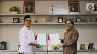 Direktur KSKK Madrasah Ditjen Pendis Kemenag Dr. A. Umar, M.A (kiri) dan Presdir Smartfren Merza Fachys (kanan) usai menandatangani nota kerjasama pemberian kartu perdana Smartfren gratis untuk Madrasah se-Indonesia untuk mendukung program PJJ, di Jakarta, Senin (21/9/2020). (Liputan6.com/HO/Agus)