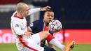 Striker Paris Saint Germain, Kylian Mbappe (kanan), berebut bola dengan bek RB Leipzig, Angelino, dalam laga lanjutan Liga Champions 2020/21 di Parc des Princes Stadium, Paris, Rabu (25/11/2020). PSG mengalahkan Leipzig dengan skor 1-0. (AFP/Franck Fife)
