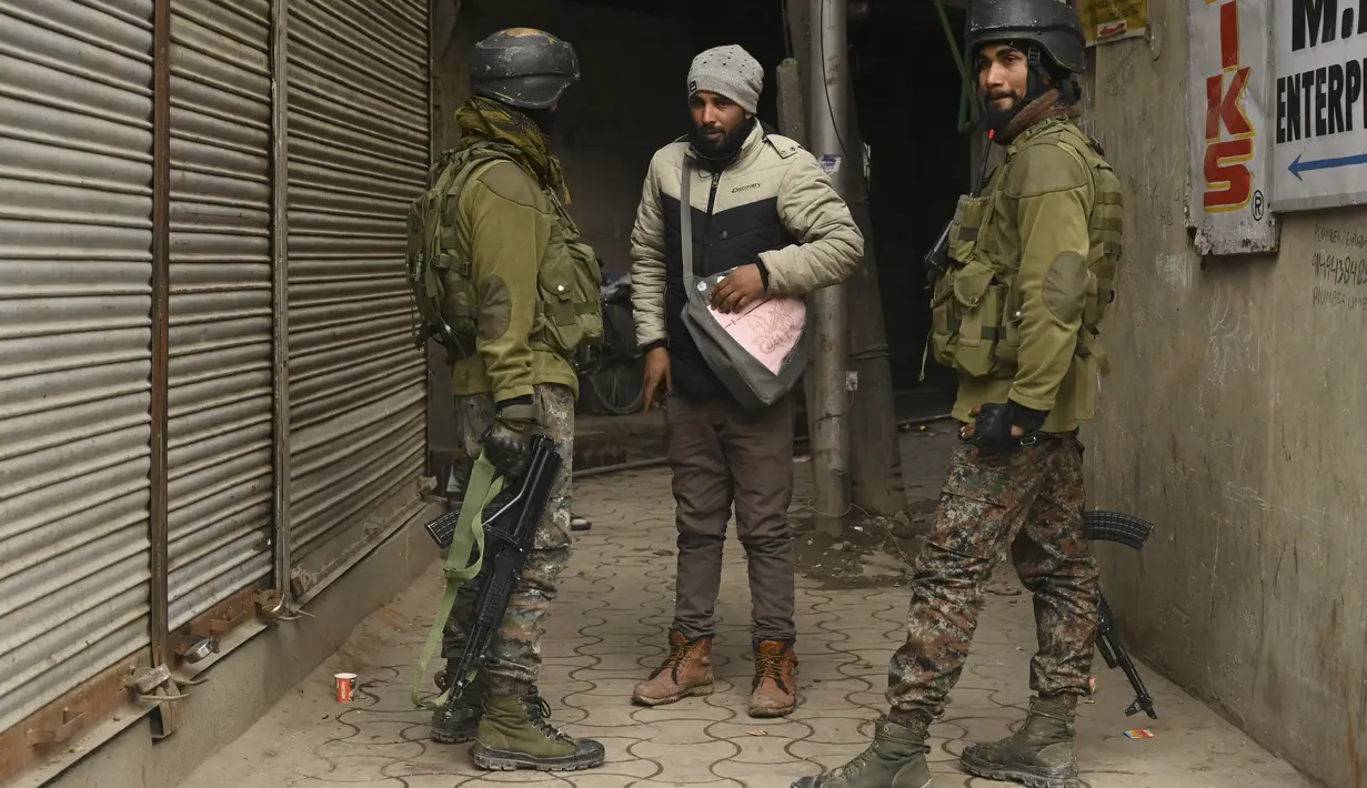 Personel Special Operation Group (SOG) menanyai seseorang di sepanjang jalan selama pencarian acak pejalan kaki di Srinagar, kota terbesar di Kashmir, Jumat (21/1/2022). Peningkatan keamanan dilakukan menjelang Hari Republik India pada 26 Januari mendatang. (TAUSEEF MUSTAFA / AFP)