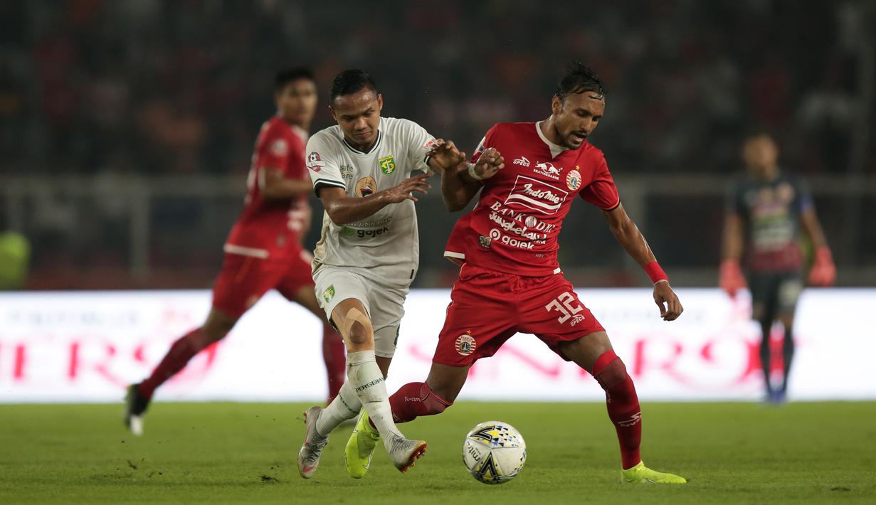 Gelandang Persija Jakarta, Rohit Chand, berebut bola dengan pemain Persebaya pada laga Shopee Liga 1 di SUGBK, Jakarta, Selasa (17/12). Persebaya menang 2-1 atas Persija. (Bola.com/Yoppy Renato)