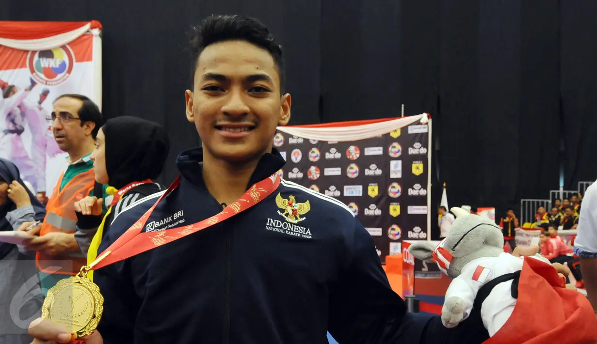 Ahmad Zigi Zaresta memamerkan medali yang diperoleh di nomor Junior Kata Male di WKF World Junior, Cadet and U-21 Championship 2015 di ICE Serpong, Banten, Kamis (12/11/2015). Zigi menyumbang emas pertama bagi Indonesia. (Liputan6.com/Helmi Fithriansyah)