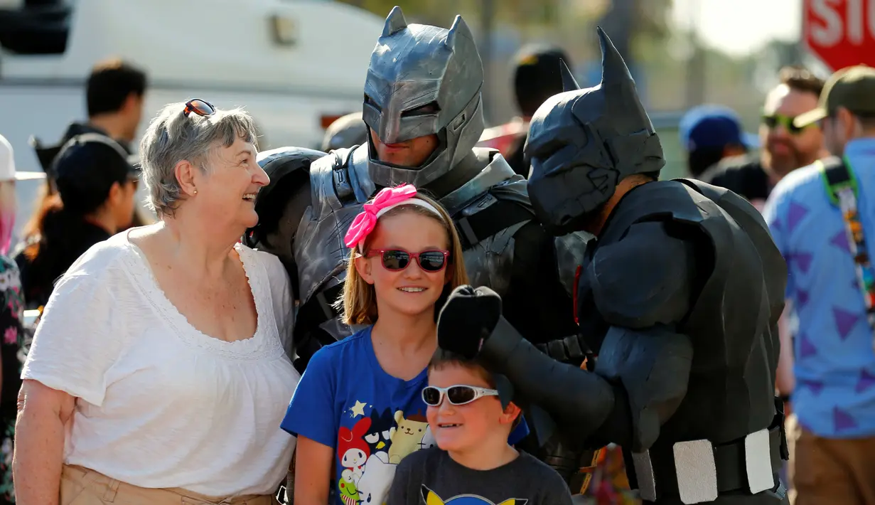 Peserta berpakaian seperti Batman menyapa penggemar selama hari pembukaan tahunan Comic-Con International di San Diego, California, Amerika Serikat, (21/7). (REUTERS/Mike Blake)