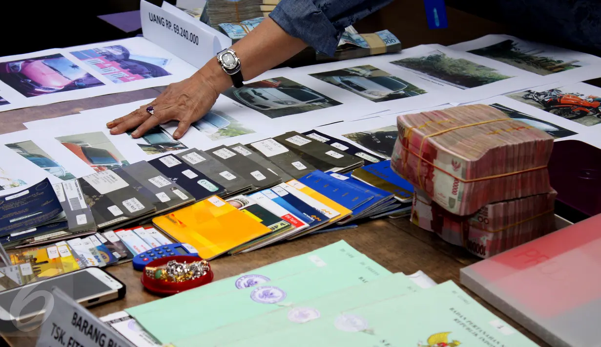 Petugas menunjukkan barang bukti kasus pencucian uang hasil bisnis narkotika ke dalam bisnis jual beli kendaraan roda empat di Gedung BNN, Jakarta, Jumat (21/8/2015). Total aset yang disita diperkitakan mencapai Rp 4,6 miliar.(Liputan6.com/Gempur M Surya)