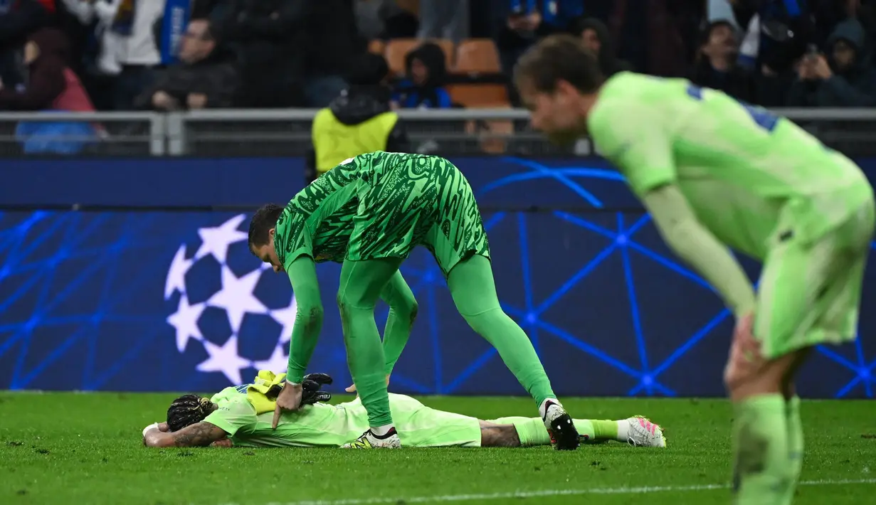 Kiper Barcelona asal Polandia, Wojciech Szczesny menghibur Raphinha setelah pertandingan sepak bola leg kedua semifinal Liga Champions 2024/2025 melawan Inter Milan di Stadion San Siro, Milan, 6 Mei 2025 waktu setempat atau Rabu (7/5/2025) dini hari WIB. (PIERO CRUCIATTI/AFP)