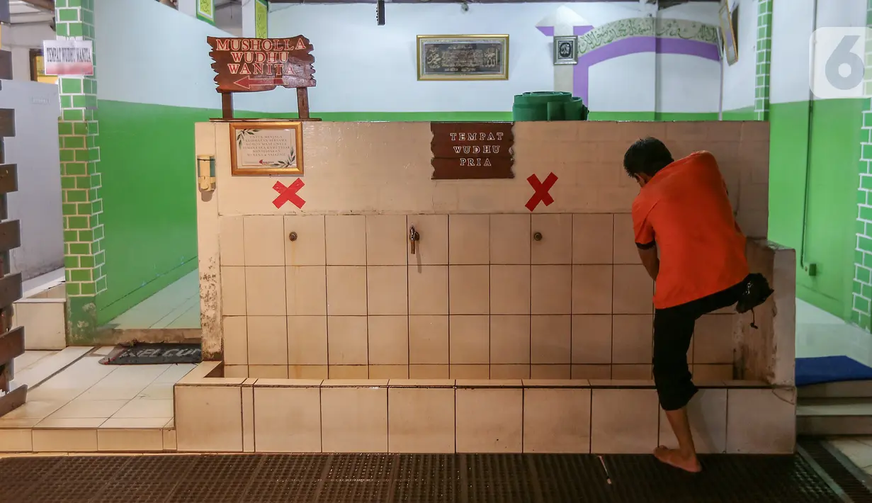 Pengunjung berwudhu yang ditempel stiker physical disatancing di Restoran Bandar Djakarta, Alam Sutera, Tangerang Selatan, Rabu (10/6/2020). Memasuki PSBB yang keempat di Tangerang Raya restoran tetap menerapkan protokol kesehatan guna menekan penyebaran virus Covid-19 (Liputan6.com/Fery Pradolo)