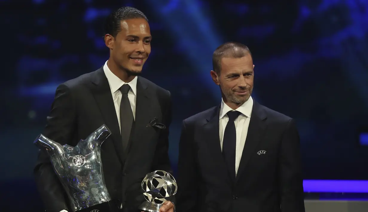 Bek Liverpool Virgil van Dijk (kiri) memegang piala penghargaan Pemain Terbaik Eropa 2018-2019 saat berpose bersama Presiden UEFA Aleksander Ceferin selama undian babak grup di Grimaldi Forum, Monako, Kamis (29/8/2019). Van Dijk mengungguli Lionel Messi dan Cristiano Ronaldo. (AP Photo/Daniel Cole)