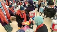 Sejumlah jemaah haji terpaksa membongkar lagi kopernya untuk mengeluarkan barang-barang yang dilarang dibawa dalam penerbangan pulang ke Tanah Air. Pembongkaran koper ini dilakukan di Terminal Haji Bandara King Abdul Aziz, Jeddah, Arab Saudi. (Liputan6.com/Dinny Mutiah)