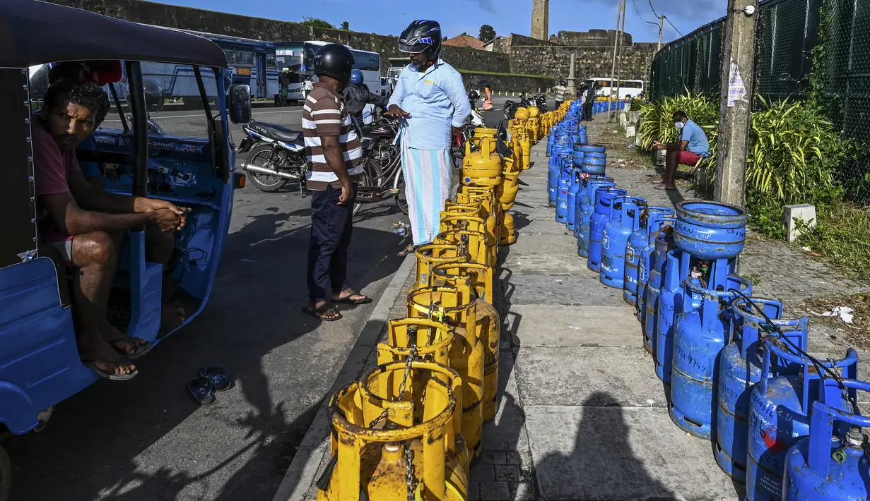 <p>Orang-orang membeli tabung Liquefied Petroleum Gas (LPG) di dekat Stadion Kriket Internasional Galle di Galle, Sri Lanka, Selasa (28/6/2022). Selain persoalan gas dan BBM, masyarakat juga dihadapkan dengan harga barang kebutuhan pokok yang semakin mahal akibat nilai inflasi yang terus meningkat. (ISHARA S. KODIKARA / AFP)</p>