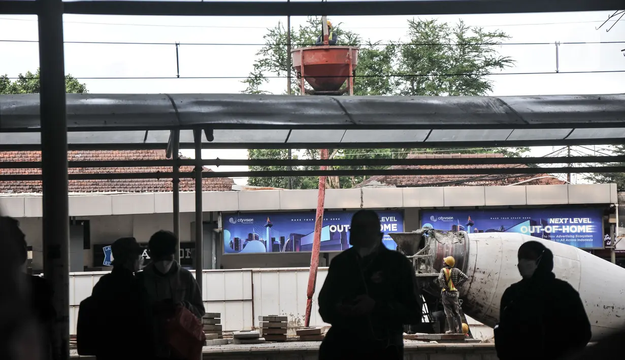 Calon penumpang kereta listrik Commuterline (KRL) saat melintas di dekat proyek pembangunan Stasiun Manggarai, Jakarta, Rabu (22/2/2023). Stasiun Manggarai nantinya akan menjadi stasiun antarmoda yang terintegrasi dengan LRT, Transjakarta dan transportasi umum lainnya serta melayani KA Bandara dan nantinya Kereta Jarak Jauh. (merdeka.com/Iqbal S Nugroho)