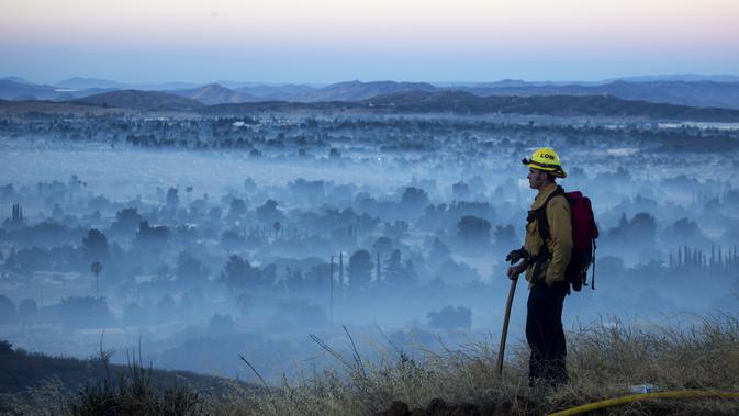 Petugas melihat kebakaran hutan di Cherry Valley, California (1/8/2020). Menurut Departemen Pemadam Kebakaran Wilayah dan Departemen Kehutanan dan Perlindungan Kebakaran California (Cal Fire), api telah meluas sejak Jumat (31/7) malam menjadi 4.125 hektar. (AP Photo/Ringo H.W. Chiu)