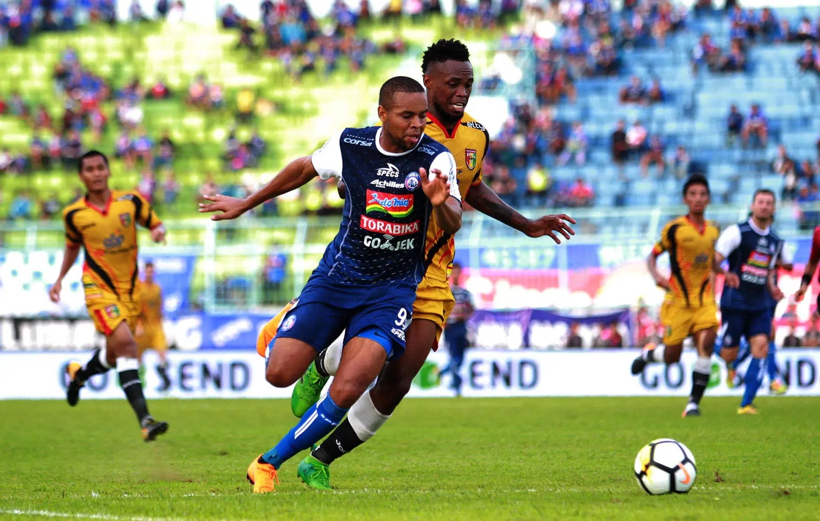 Thiago Furtuoso berduel dengan Mauricio Leal pada laga Arema vs Mitra Kukar di Stadion Kanjuruhan, Malang, Sabtu (24/3/2018). (Bola.com/Iwan Setiawan)
