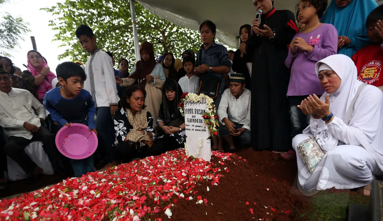 Sejumlah keluarga, kerabat dan sahabat berdoa seusai pemakaman penyanyi Yanni Rusiana Djunaedi atau Yanni Libels di TPU Tanah Kusir, Jakarta, Kamis (26/3/2015). (Liputan6.com/Panji Diksana)  