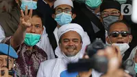Rizieq Shihab (tengah) memberi keterangan sesaat sebelum masuk gedung utama Mapolda Metro Jaya, Jakarta, Sabtu (12/12/2020). Rizieq Shihab akan menjalani pemeriksan sebagai tersangka penghasutan dan kerumunan di tengah pandemi Covid-19. (Liputan6.com/Helmi Fithriansyah)