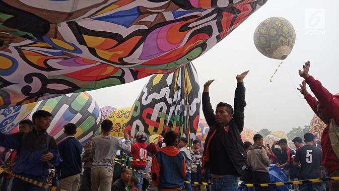 Peserta bersiap menaikan balon udara di Lapangan Pagerejo, Kertek, Kabupaten Wonosobo,  Sabtu (15/6/2019). Festival ini untuk memeriahkan syawalan dan wujud syukur warga yang hidup di lereng gunung sindoro dan sumbing. (Liputan6.com/Gholib)