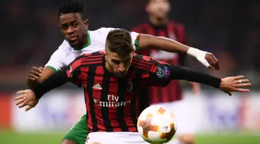 Pemain AC Milan, Fabio Borini  dan gelandang Ludogorets Razgrad, Virgil Roy Misidjan berebut bola pada leg kedua babak 32 besar Liga Europa, di San Siro, Milan, Kamis (22/2). Milan menang tipis 1-0 sehingga lolos ke babak 16 besar. (MARCO BERTORELLO/AFP)