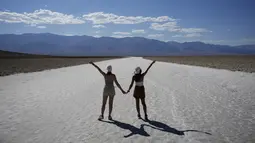 Orang-orang berpose untuk foto di dataran garam di Badwater Basin, di Taman Nasional Death Valley, Taman Nasional Death Valley, California, Kamis (1/9/2022). Menurut Organisasi Meteorologi Dunia, tercatat suhu terpanas di kawasan ini pernah mencapai 45 derajat Celcius, yang terjadi pada 22 April 2012 silam. (AP Photo/John Locher)