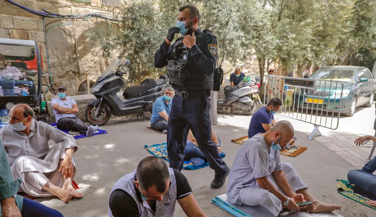 Anggota pasukan keamanan Israel berjaga saat seorang jemaah Palestina menghadiri salat Jumat selama bulan suci Ramadan di tengah krisis pandemi coronavirus di luar kompleks masjid al-Aqsa di Kota Tua Yerusalem (15/5/2020). (AFP/Ahmad Gharabli)