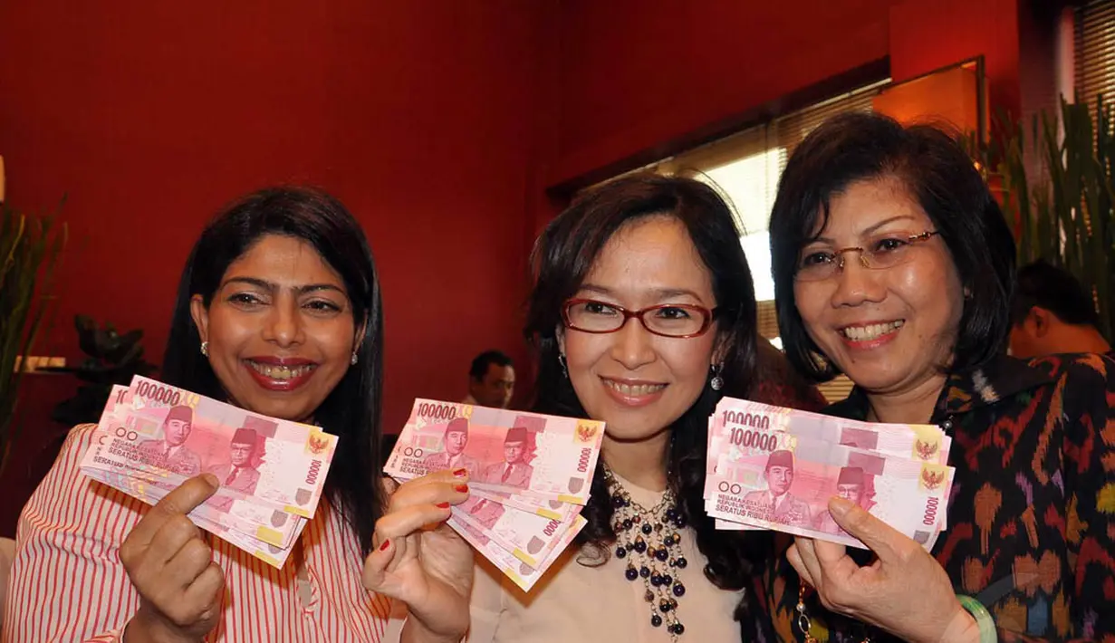 Petugas menunjukan uang kertas pecahan Rp. 100.000 baru usai launching uang tersebut di Bank Indonesia, Jakarta, Senin (18/8/14). (Liputan6.com/Miftahul Hayat)