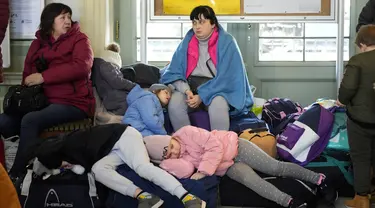 Anak-anak dari Ukraina tidur di stasiun kereta api di Przemysl, Polandia tenggara, pada Rabu (23/3/2022). Polandia telah menerima lebih dari 2 juta pengungsi Ukraina sejak invasi Rusia pada 24 Februari lalu. (AP Photo/Sergei Grits)