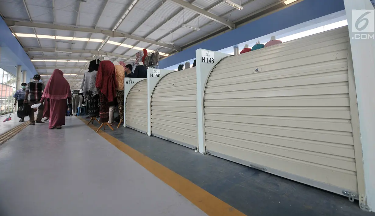Pengunjung melintasi sejumlah kios pedagang yang masih tutup di Skybridge atau jembatan multiguna Tanah Abang, Jakarta, Selasa (11/12). Baru 345 dari 446 lapak yang sudah dihuni pedagang di Skybridge Tanah Abang. (Merdeka.com/Iqbal Nugroho)