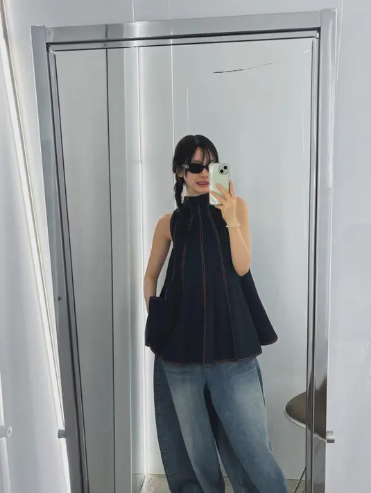 Seperti saat berada di Tokyo, Ningning tampil dengan gaya yang swag dan menggemaskan dengan atasan sleeveless denim yang memberikan siluet flowy dan unk. Ia memadukannya dengan celana baggy warna biru pudar serta kacamata hitam yang memberi kesan cool dan misterius. Gaya rambutnya dikepang dua memberikan sentuhan cute yang kontras. [@imnotningning].