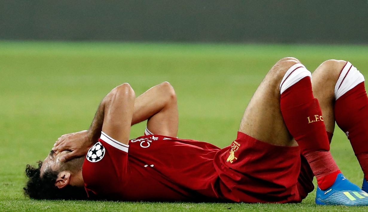 Pemain Liverpool Mohamed Salah kesakitan usai dicederai oleh bek Real Madrid Sergio Ramos dalam pertandingan final Liga Champions di Stadion NSK Olimpiyskiy, Ukraina (26/5). Karena cedera Salah tidak dapat melanjutkan pertandingannya. (AP/Pavel Golovkin)