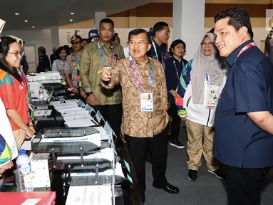 Wakil Presiden, Jusuf Kalla didampingi Ketua INASGOC, Erick Thohir berbincang dengan relawan media registrasi di Main Press Center (MPC) atau Media Center Asian Games di JCC, Jakarta, Selasa (14/8). (Liputan6.com/Fery Pradolo)