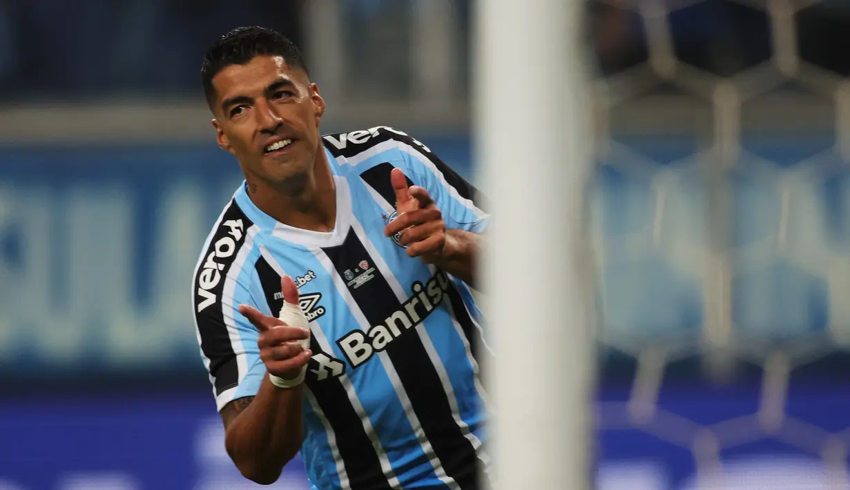 Stiker Gremio Luis Suarez berselebrasi setelah mencetak gol ke gawang Sao Luiz pada ajang Recopa Gaucha di stadion Arena do Gremio di Porto Alegre, Brasil, Selasa (17/1/2023). Mantan penyerang Barcelona hingga Liverpool itu membuka keran golnya di menit kelima saat bersua Sao Luiz. (SILVIO AVILA / AFP)