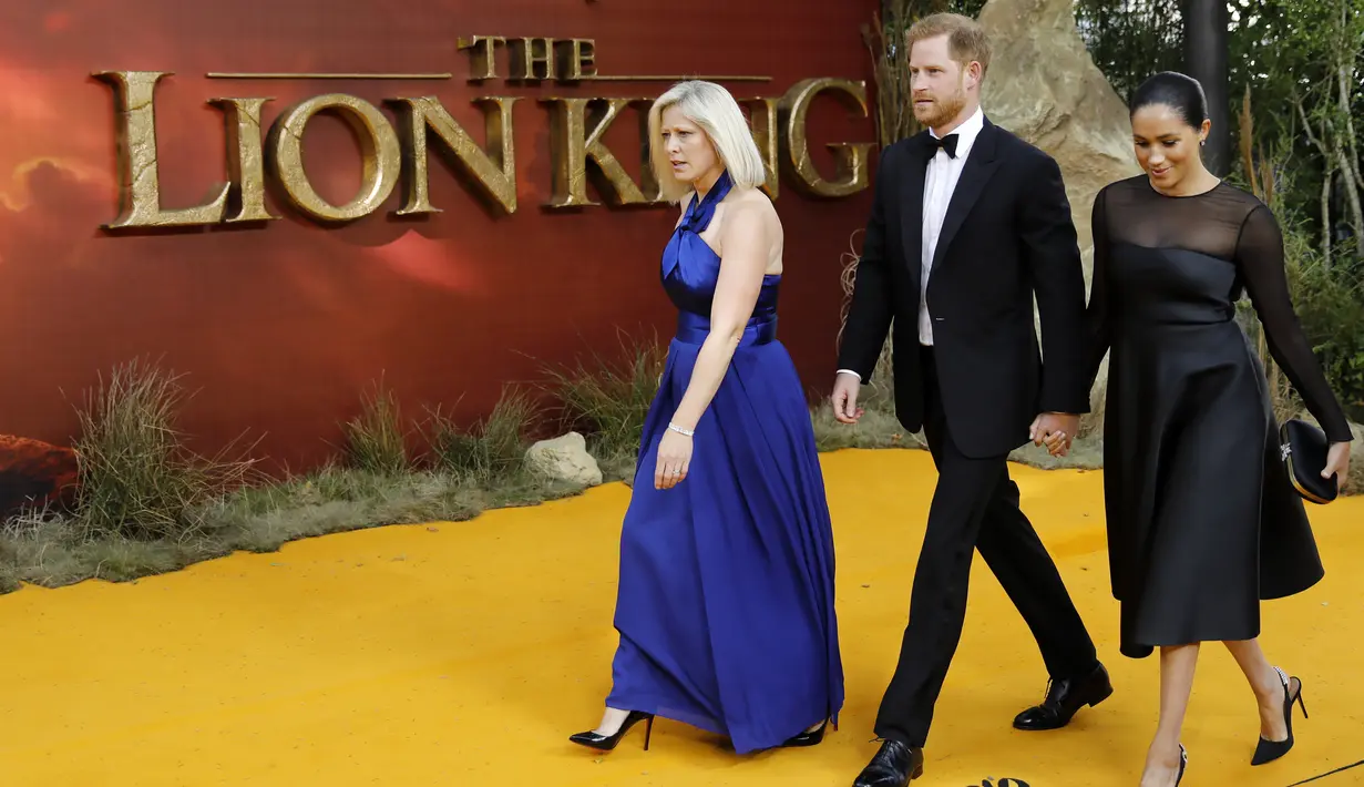 Pangeran Harry dan Meghan Markle tiba menghadiri pemutaran perdana film The Lion King di London (14/7/2019). Duchess of Sussex tampil menawan dalam balutan gaun hitam dengan detail lebar di bagian bawah rok. (AFP Photo/Tolga Akmen)