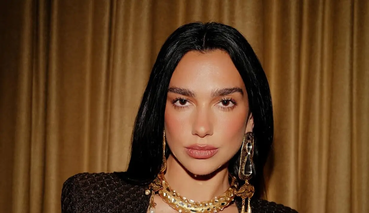 <p>Gaun berpotongan v-neck rendah yang dipadu dengan kalung emas siluet emas bergaya Aztec [@dualipa]</p>