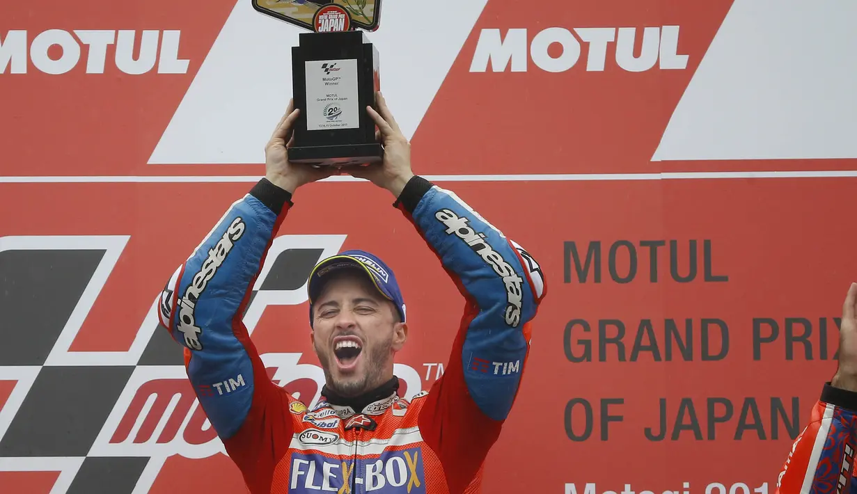 Pebalap Ducati, Andrea Dovizioso, mengangkat trofi usai mejuarai balapan MotoGP Jepang di Sirkuit Motegi, Minggu (15/10/2017). Andrea Dovizoso menyelesaikan balapan dengan catatan waktu 47 menit 14,236 detik. (AP/Shizuo Kambayashi)