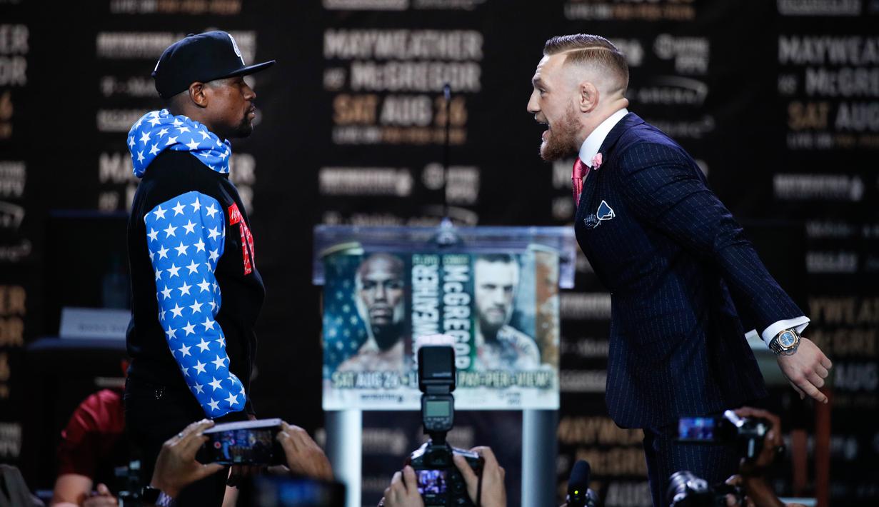  Juara mixed martial arts Conor McGregor (kiri) dan petinju Floyd Mayweather Jr bertatapan saat jumpa pers di Staples Center Los Angeles, AS (12/7). Mayweather dan McGregor akan bertanding pada 26 Agustus 2017. (AP Photo/Jae C. Hong)